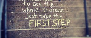 Skrevet med kridt på trappetrin: "You don't have to see the whole staircase, just take the first step"